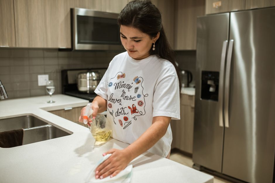 Professional wiping kitchen counter during recurring cleaning